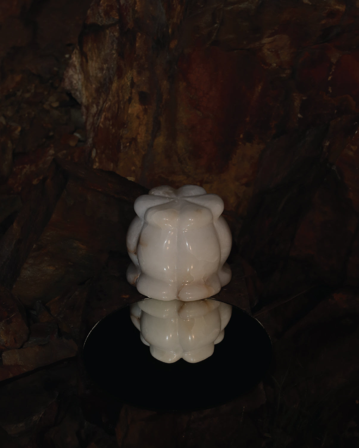 Lira Table Lamp placed within a natural stone setting