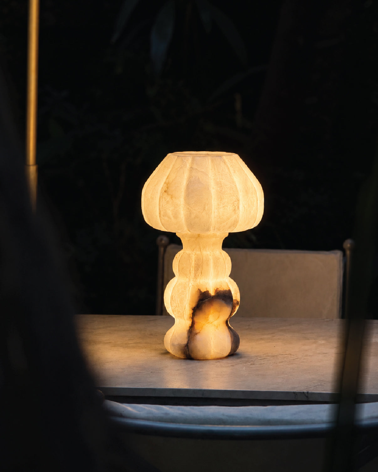 Noura Table Lamp softly illuminating a dim interior space